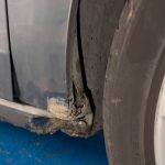 Cena ispravljanja bocnog dela automobila ispod vrata suvozaca i iza prednjeg tocka usled nalegnuca na visoki trotoar.